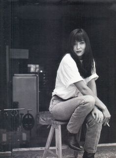 a woman sitting on top of a stool