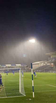 a soccer goalie getting ready to block the ball from going into the net at night