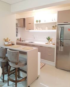 a kitchen with two stools and a refrigerator