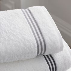 towels stacked on top of each other in a row with black and white striped lines