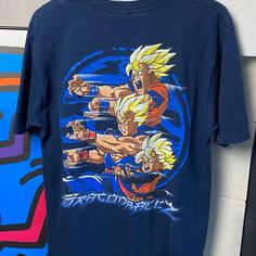 a blue shirt with the image of gohan and trunks on it hanging from a wall