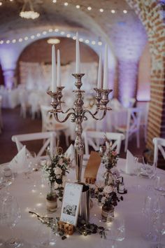 the centerpieces on this table are decorated with flowers and candles for an elegant touch