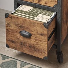 an old wooden file cabinet with drawers on wheels is open to reveal files and folders