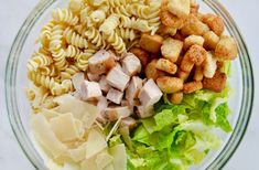 pasta salad with chicken, lettuce and croutons in a glass bowl