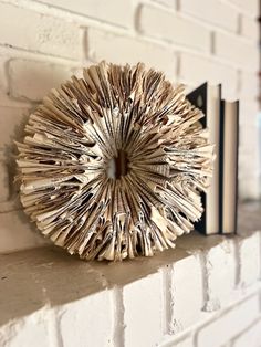 an open book is sitting on top of a shelf next to a wall mounted clock