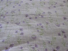 a bed with purple and green flowers on it