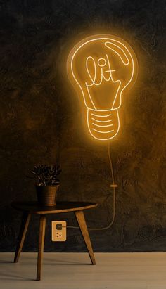 a yellow light bulb sitting on top of a wooden table next to a black wall