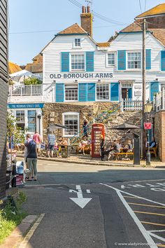 an old borough arms pub on the corner of a street with people walking around it