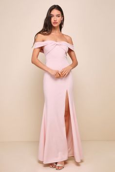 a woman wearing a pink dress with an off the shoulder slit