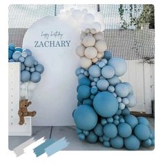 there is a blue and white balloon tree next to a teddy bear