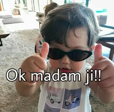 a young boy wearing sunglasses giving the thumbs up sign with words ok madam jii