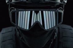 a helmet with goggles and sunglasses on top of it, in front of a black background