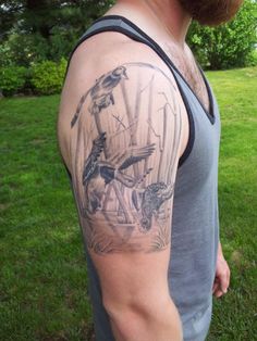 a man with a goat and birds tattoo on his arm is standing in the grass