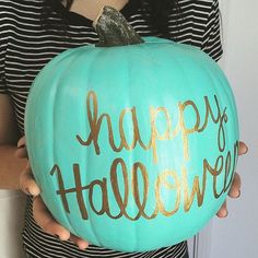 a person holding a large pumpkin with the words happy halloween painted on it