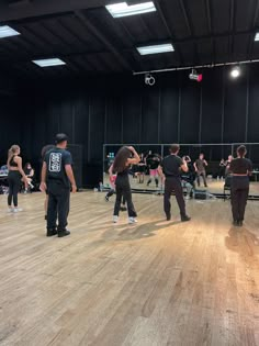 a group of people standing on top of a wooden floor next to each other in a gym