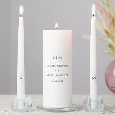 three white candles sitting next to each other on a table