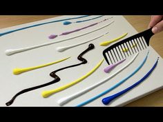 a person is holding a comb over an assortment of toothbrushes on a white board