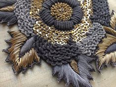 a close up of a piece of cloth with gold and black flowers on it