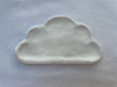 a white cloud shaped dish sitting on top of a table