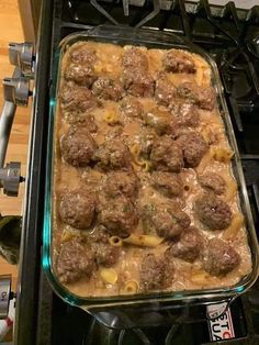 a casserole dish filled with meatballs and sauce on top of a stove