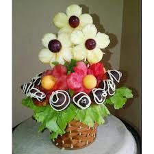 a basket filled with fruit and flowers on top of a table