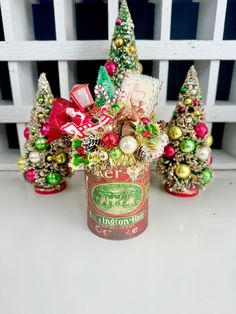 small christmas trees and ornaments in an old can