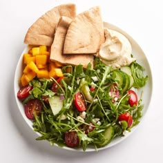 a white plate topped with salad and pita bread