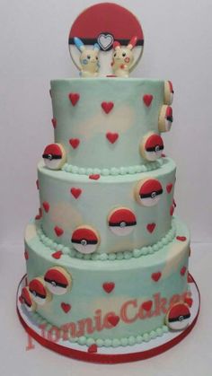 a three tiered cake with pokemon characters on it's sides and hearts around the edges