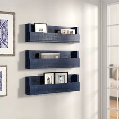 three blue shelves on the wall in a living room