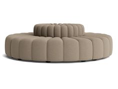 the circular couch is made out of fabric and has four legs, one foot on top of