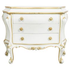 an ornate white and gold dresser with drawers