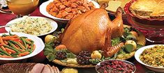 a large turkey surrounded by many different types of thanksgiving foods and vegetables on a table