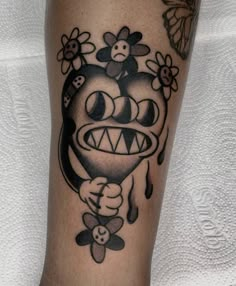 a tattoo on the leg of a person with a monkey and flowers around his neck