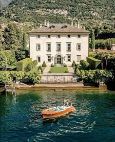 a boat in the water near a large house