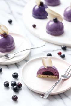 two plates with desserts on them, one is purple and the other has blueberries