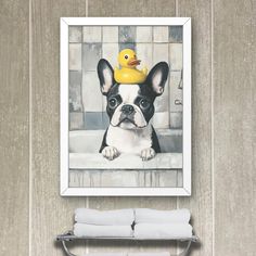 a painting of a dog with a rubber ducky on it's head hanging above a towel rack