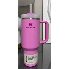 a pink travel mug sitting on top of a table