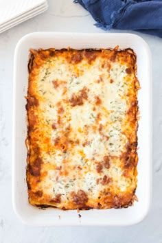 a casserole dish with meat and cheese in it on a white counter top