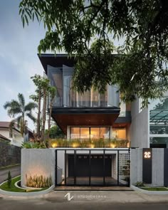 a modern house with an open garage and balcony above the garage is surrounded by greenery