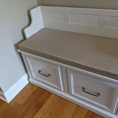 a white bench with two drawers on top of it