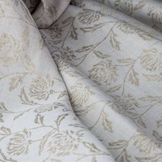 a close up view of a fabric with gold flowers and leaves on it, as well as the background