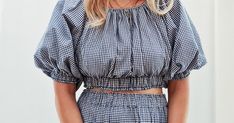 a blonde woman wearing a blue and white checkered top with matching shorts is posing for the camera