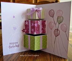 a birthday card with some balloons on it and a gift box in the middle that says happy birthday