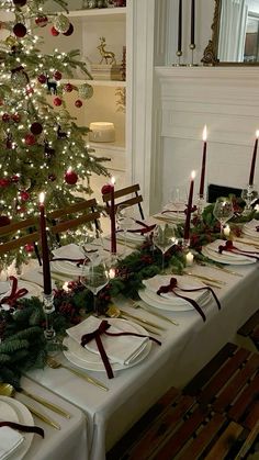 a table set for christmas with candles and plates