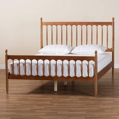 a wooden bed frame with white pillows on it