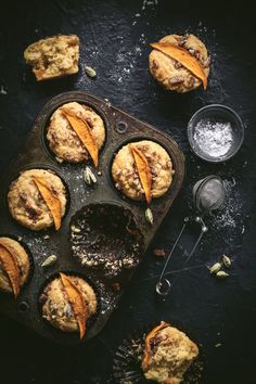 some muffins are sitting in a muffin tin on top of a table