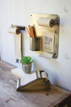 a wooden table topped with a potted plant next to a wall mounted mailbox