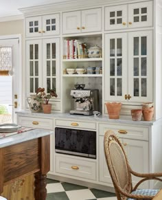 a kitchen with white cabinets and black and white checkered flooring on the floor