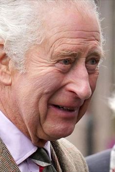 an older man wearing a suit and tie looking off to the side with his eyes wide open