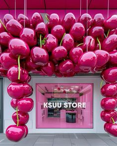 the entrance to a store with pink balloons hanging from it's ceiling